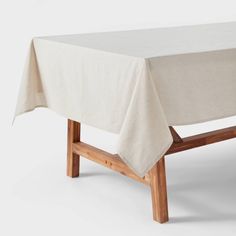 a wooden bench with a white tablecloth on it's back end and legs