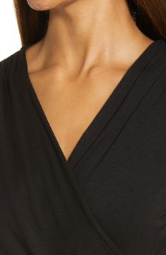 A faux-wrap front flatters on this soft and versatile jersey top cinched with a saucy tie at the hip. 23 1/2" length Surplice V-neck Short sleeves 95% rayon, 5% spandex Machine wash, dry flat Imported Women's Clothing V-neck Wrap Top With Tie Waist For Work, Solid Color V-neck Faux Wrap Top, V-neck Faux Wrap Top For Layering, Chic Surplice Neckline Top For Layering, V-neck Wrap Top For Loungewear, Fall Wrap Top With Surplice Neckline, Faux Wrap V-neck Top For Layering, Chic V-neck Top With Tie Waist, Faux Wrap Top For Layering