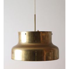 a large brass pendant light hanging from a ceiling