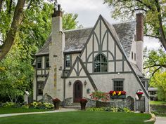 an old house with flowers in the front yard