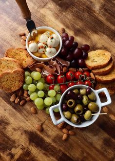 a wooden table topped with different types of food and breads on top of it