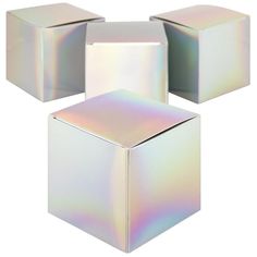 three white boxes with iridescent holographics on them