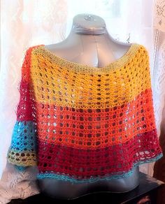 a colorful crocheted sweater is sitting on a mannequin