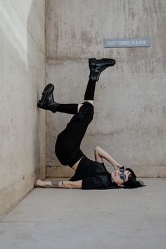 a woman is laying on the ground with her legs up in the air while wearing black shoes