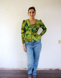 "Vintage cropped peplum blouse in lively shades of green blue and orange with gold buttons, high waist, made of polyester, the body is fully lined with green satin, puffy sleeves, aside from minor signs of wear including three small pinholes on the inner back panel. Nevertheless, good vintage condition clean, ready to wear  ** Model is 5'7\" and size S for reference. proximate size: S -  Please refer to the measurements. M E A S U R E M E N T S -were taken with garments laying flat, please doubl Retro Green Tops For Fall, Fitted Green Tops With Retro Print, Fitted Green Top With Retro Print, Fitted Groovy Spring Tops, Fitted Groovy Tops For Spring, Green Cropped Blouse For Fall, Vintage Fitted Green Tops, Vintage Cropped Blouse For Spring, Retro Fitted Green Top