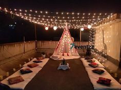 an outdoor party setup with lights and pillows