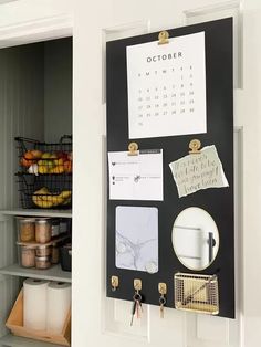 a black and white calendar is hanging on the wall next to a shelf with other items