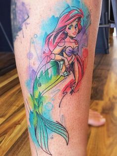 a colorful mermaid tattoo on the leg