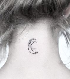 a woman's neck with a small crescent tattoo on the back of her neck