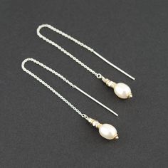 These Unique Pair of Long White Pearl Threader Earrings are handcrafted for you with great care. Handmade with beautiful Freshwater Pearls, each with its unique shape. Each pair of pearls are hand-matched to the size but no two will be exactly the same. The earrings have a dainty and feminine look. They will be a fabulous addition to your jewelry collection and a great present for June's Birthdays! MATERIALS AND SIZE ◆ Metal - 14k Gold Filled, 925 Sterling Silver ◆ Thread Thought Earrings measur Handmade Elegant Dangle Threader Earrings, Elegant Handmade Long Drop Threader Earrings, Delicate White Threader Earrings For Gift, Delicate White Threader Earrings As Gift, Silver Round Threader Earrings Gift, Dangle Pearl Drop Threader Earrings As Gift, Classic Pierced Threader Earrings As A Gift, White Threader Earrings With Ear Wire For Gift, White Threader Earrings As A Gift