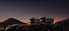 three cameras sitting on top of a rock in front of some mountains at night time