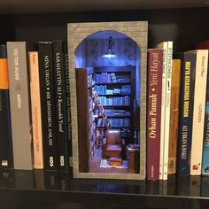 a book shelf filled with lots of books next to a doorway in the wall behind it