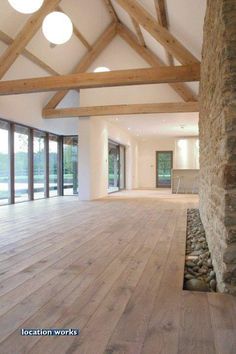 an empty room with wood floors and large windows