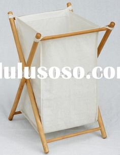 a white canvas laundry hamper with wooden handles