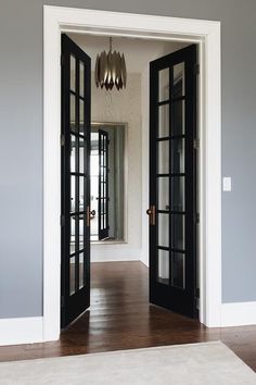 an open door leading to another room with wood flooring and walls painted in gray