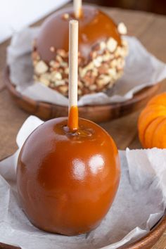 two caramel apples with sticks sticking out of them