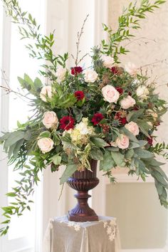 a vase filled with lots of flowers on top of a table