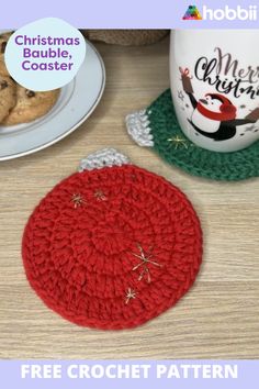 a crocheted christmas ornament next to a coffee cup on a table