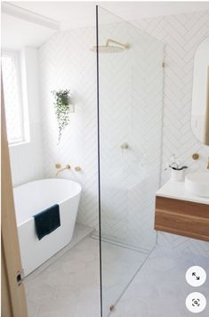 a bathroom with a tub, sink and mirror