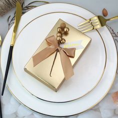 a white plate topped with a gold gift box