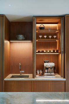 a kitchen with wooden cabinets and stainless steel appliances on the countertop, along with an espresso machine