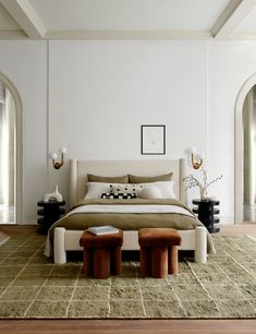 a large bed sitting on top of a wooden floor next to two tables and lamps