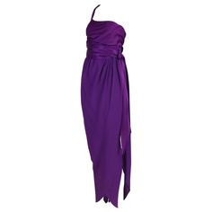 1970's Halston purple silk evening gown with a single shoulder strap and wrap skirt featuring a draped waist tie. The silk fabric which the bodice and waist tie are fabricated from is shiny silk satin while the skirt fabric is either a silk crepe de chine or silk crepe. In excellent condition with a very hard to see mark at the front bodice. No size or fabric tag - please consult measurements. MEASUREMENTS: Bust - 32" Waist - 26" Hips - 36" Skirt length - 47.5" Bodice length- 14" Purple Silk Dress, Chiffon Halter Dress, Halston Dress, Purple Evening Dress, Silk Evening Gown, Liza Minnelli, Robes Vintage, Cocktail Dress Vintage, Silk Chiffon Dress