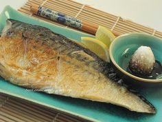 a fish is sitting on a plate with some dipping sauce