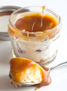 a spoon full of caramel cheesecake in a jar