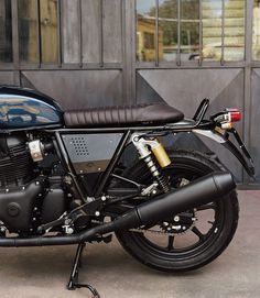 a black motorcycle parked in front of a building