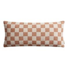 an orange and white checkered pillow on a white background