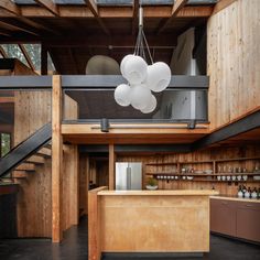 an open kitchen and dining area in a house with wooden walls, flooring and ceiling