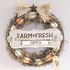 a sign that says farm fresh is hanging on the wall next to a wreath with eggs in it