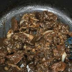 beef and mushrooms cooking in a pan on the stove