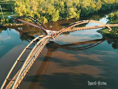 an aerial view of a bridge over a river in the middle of trees and water