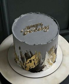 a birthday cake decorated with gold and silver frosting