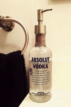 a bottle of absolut vodka sitting on a counter next to a towel rack