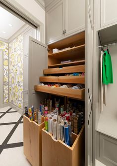 an organized pantry in a white kitchen with lots of drawers and items on the bottom shelf