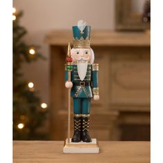 a nutcracker figurine on a table in front of a christmas tree