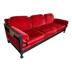 a red couch sitting on top of a white floor next to a wooden frame and black legs