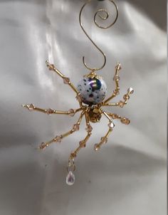 a gold spider brooch sitting on top of a white cloth