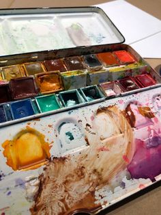 an artist's palette with lots of paint on it