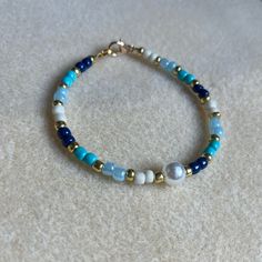 - One Of A Kind Beaded Bracelet - Featuring Blue, White, And Gold Seed Beads With A White Pearl Bead At The Center - Gold Colored Hardware - Clasps Closed. No Stretch. - Size/ Circumference Is 7” - Handmade (By Myself). Perfect To Treat Yourself Or To Give As A Unique Gift! **Add 2 Jewelry Items Marked “2 For $20” To Your Bundle And I Will Send You An Offer For $20** Tags: Beaded, Handmade Jewelry, Colorblock, Ocean, Pearls Check Out The “Boutique” Tab In My Closet For Handmade Earrings, Bracele Blue Hand-strung Pearl Bracelet With Round Beads, Adjustable Hand-strung Blue Pearl Bracelet, Everyday Blue Hand-strung Beaded Bracelets, Adjustable Blue Bohemian Pearl Bracelet, Adjustable Bohemian Blue Pearl Bracelet, Blue Pearl Bracelet With Spacer Beads, Blue Beaded Pearl Bracelet With Round Beads, Blue Pearl Bracelet With Colorful Beads For Beach, Bohemian Blue Pearl Bracelet With Colorful Beads