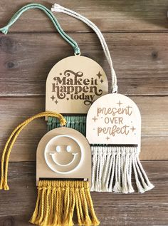 two wooden tags with tassels attached to them and the words make it happen today