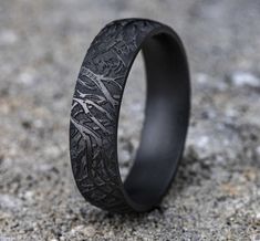 a black ring with an intricate design on the inside is shown in close up view