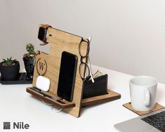 an office desk with a laptop, cell phone and other items on top of it