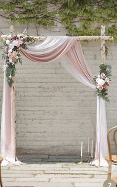 a wedding arch decorated with pink and white flowers