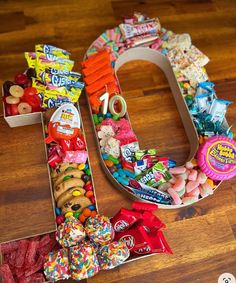 the letter u made out of candy and candies is displayed on a wooden floor