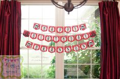 a room with red curtains and decorations on the window sill in front of a chandelier