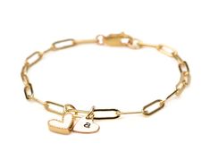 Experience the poetic harmony of love with our Personalized Love Duet Bracelet. Crafted from our delicate Gold-Plated paperclip chain, featuring 3 X 9mm links, this bracelet hosts two hearts—an enchanting fusion of one heart in white enamel and Gold-Plate and the other in 14 karat gold filled allure. Measuring about 1/4"x1/4" each, these hearts, with their distinct shapes, engage in a graceful choreography along the sophisticated paperclip chain. Customize the golden heart with a single initial, Everyday Paperclip Chain Jewelry For Valentine's Day, Valentine's Day Jewelry With Paperclip Chain, Paperclip Chain Jewelry For Mother's Day Anniversary, Valentine's Day Jewelry With Adjustable Paperclip Chain, Personalized Adjustable Paperclip Bracelet, Modern Cable Chain Charm Bracelet As Gift, White Gold Paperclip Chain Bracelet As Gift, White Gold Paperclip Chain Bracelet Gift, White Rectangular Links Jewelry For Gift